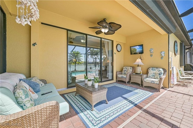 view of patio / terrace with glass enclosure, ceiling fan, and an outdoor living space