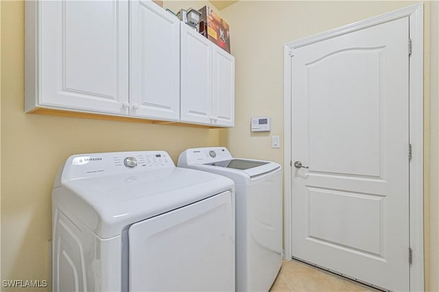 laundry room with light tile patterned flooring, cabinet space, and separate washer and dryer