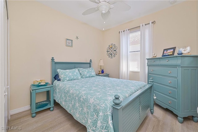 bedroom with a ceiling fan, light wood-type flooring, and baseboards