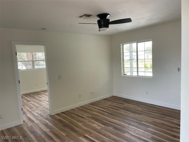 spare room featuring visible vents, ceiling fan, baseboards, and wood finished floors