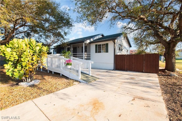 bungalow-style home with concrete driveway and a sunroom