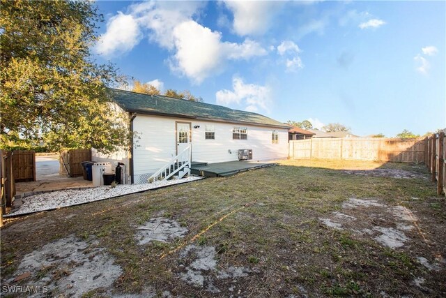 rear view of property with a lawn and a fenced backyard