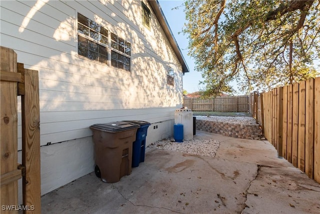 view of side of property featuring a patio, crawl space, and a fenced backyard