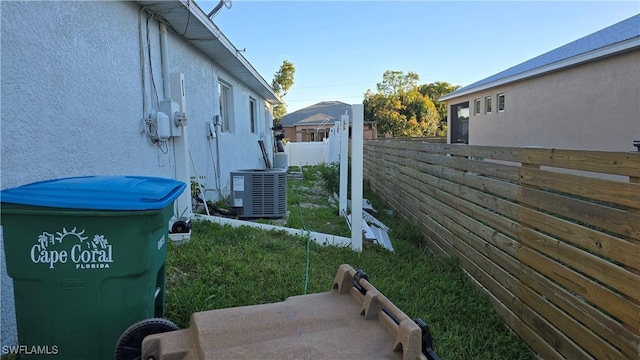 view of property exterior with central air condition unit, fence, and stucco siding