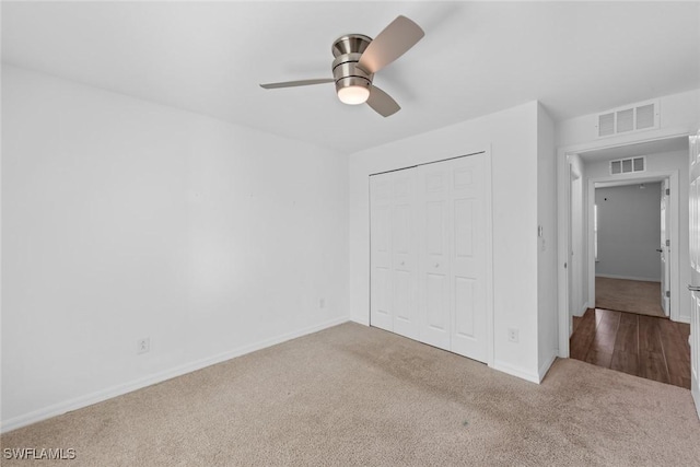 unfurnished bedroom with carpet flooring, baseboards, visible vents, and a closet