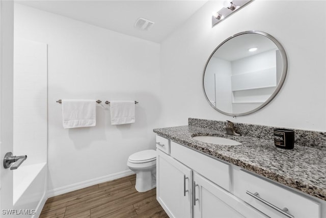 bathroom featuring vanity, wood finished floors, visible vents, baseboards, and toilet