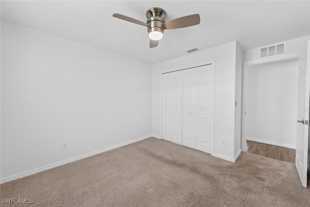 unfurnished bedroom with carpet, visible vents, and a closet