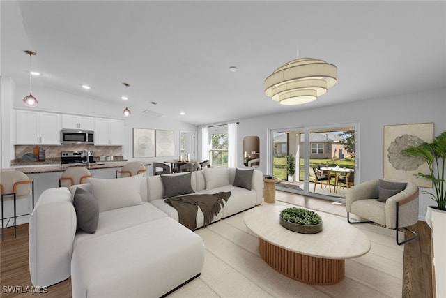 living room with recessed lighting, light wood-type flooring, and lofted ceiling