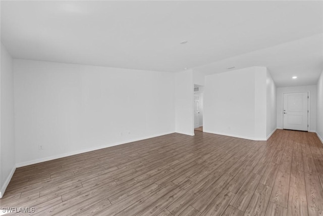 unfurnished room featuring recessed lighting, baseboards, and wood finished floors