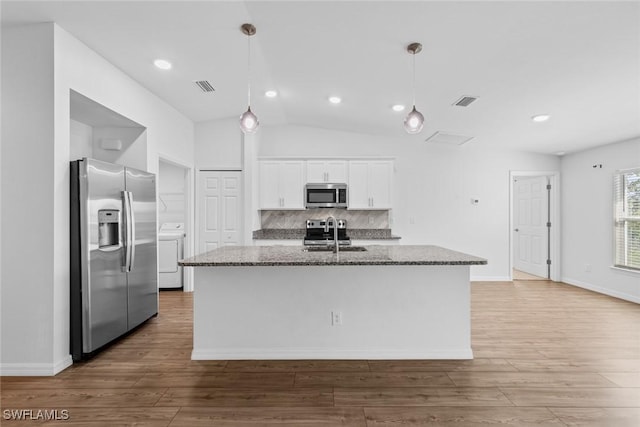 kitchen featuring visible vents, a sink, dark stone countertops, white cabinetry, and stainless steel appliances