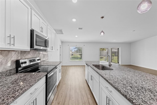 kitchen with tasteful backsplash, visible vents, light wood-type flooring, appliances with stainless steel finishes, and a sink