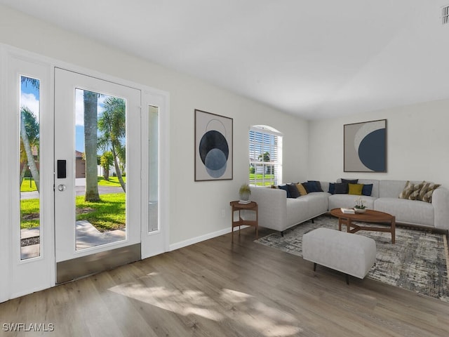 living room featuring wood finished floors, visible vents, and baseboards