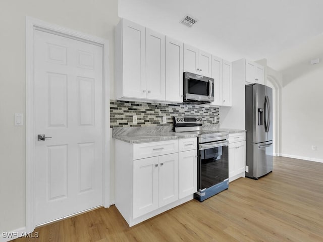 kitchen featuring tasteful backsplash, visible vents, appliances with stainless steel finishes, light wood-type flooring, and white cabinetry