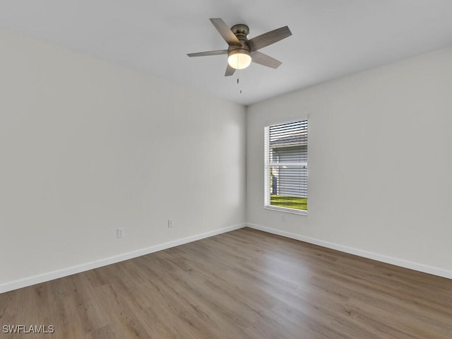 unfurnished room with a ceiling fan, baseboards, and wood finished floors