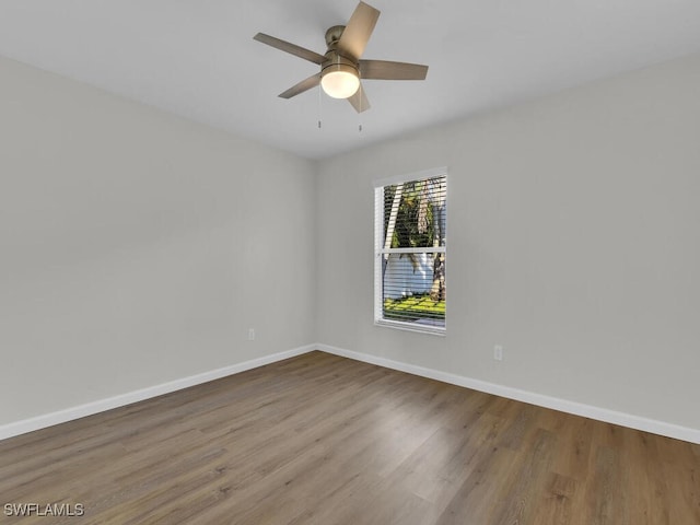 spare room featuring ceiling fan, baseboards, and wood finished floors