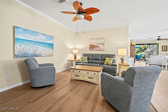 living area featuring light wood-style flooring, a ceiling fan, baseboards, and ornamental molding