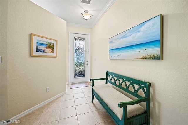 foyer entrance featuring tile patterned floors, a textured wall, baseboards, and ornamental molding