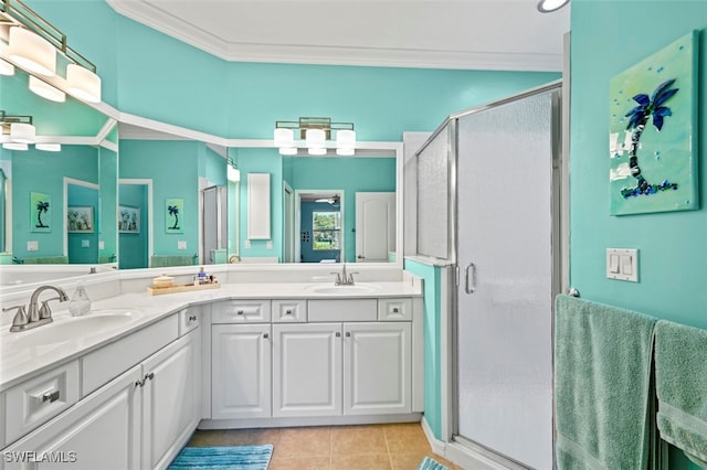 bathroom featuring tile patterned floors, crown molding, a shower stall, and a sink