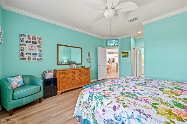 bedroom with visible vents, ornamental molding, wood finished floors, ensuite bath, and a ceiling fan