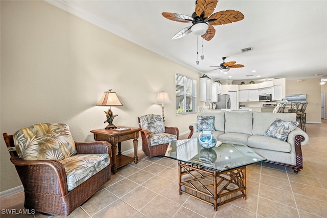 living room with light tile patterned flooring, visible vents, baseboards, and ornamental molding