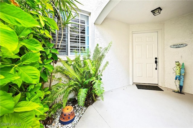 property entrance with stucco siding