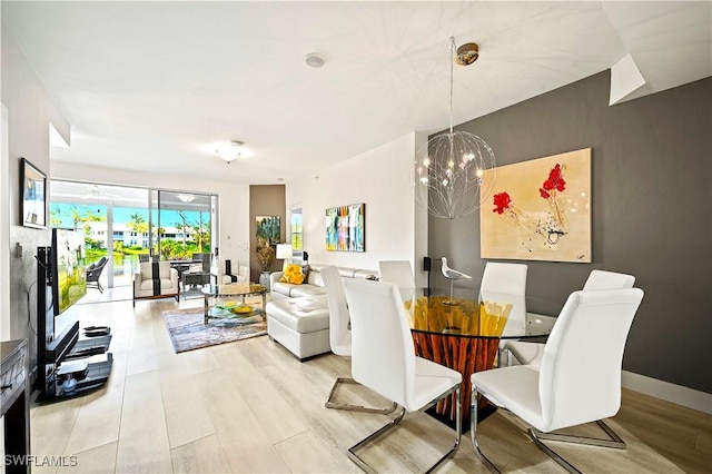 dining area featuring baseboards, an inviting chandelier, and wood finished floors