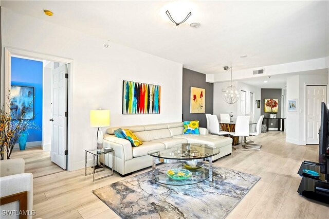 27091 Lake Harbor Ct Unit 102, Bonita Springs, FL 34134 - living area with a chandelier, light wood-style floors, and baseboards
