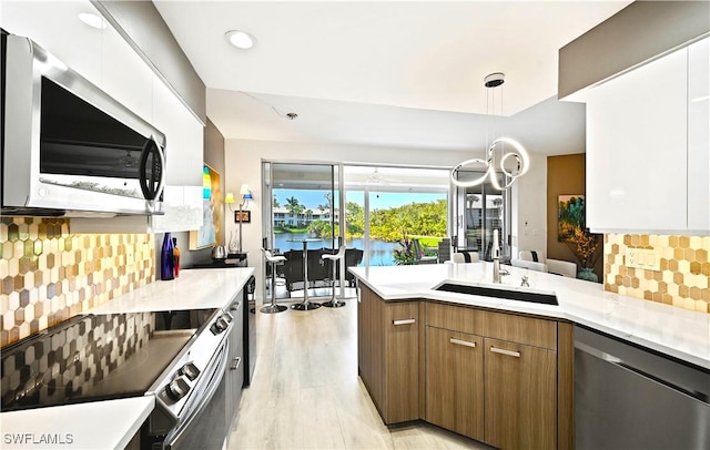 kitchen featuring modern cabinets, dishwasher, electric range oven, and light countertops