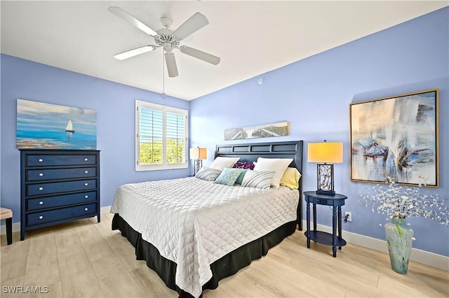 bedroom featuring a ceiling fan, baseboards, and wood finished floors