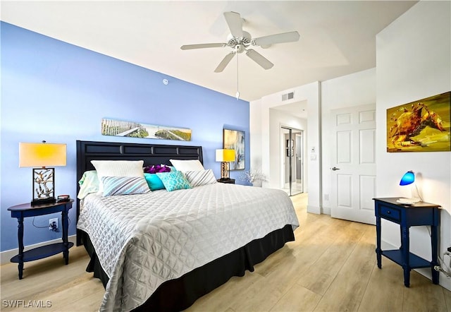 bedroom with visible vents, baseboards, light wood-style floors, and ceiling fan