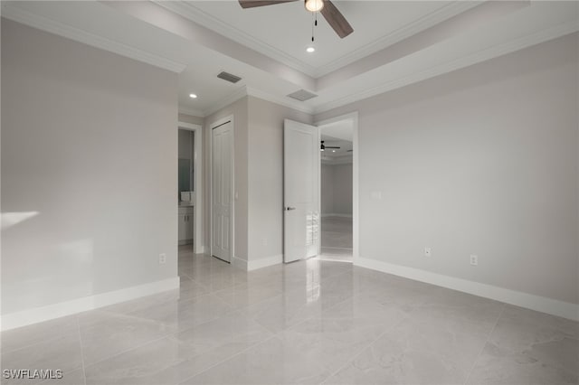 unfurnished room featuring crown molding, a raised ceiling, visible vents, and baseboards