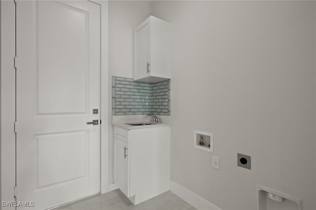 washroom featuring cabinet space, baseboards, hookup for an electric dryer, washer hookup, and a sink