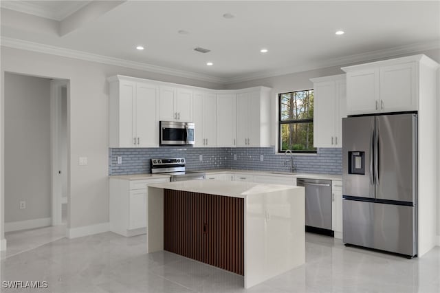 kitchen with visible vents, white cabinets, ornamental molding, stainless steel appliances, and a sink