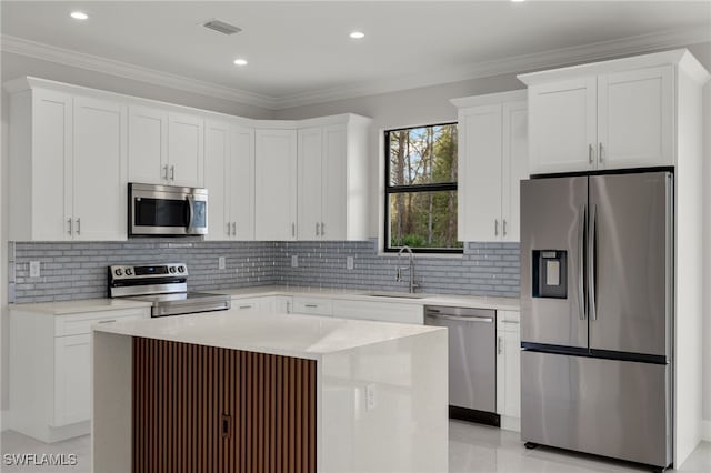 kitchen featuring stainless steel appliances, a sink, and crown molding