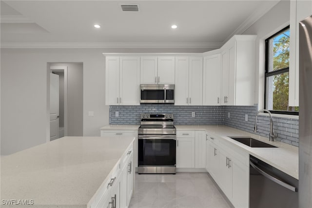 kitchen featuring a sink, visible vents, ornamental molding, appliances with stainless steel finishes, and backsplash