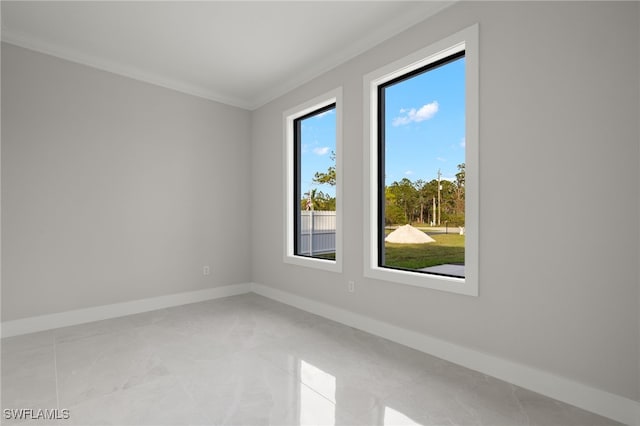 spare room featuring crown molding and baseboards