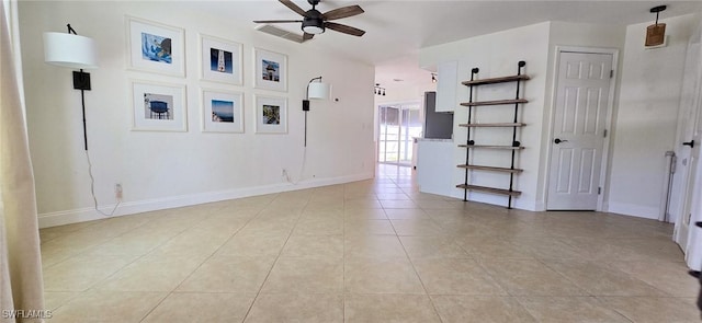 empty room featuring light tile patterned floors, baseboards, and ceiling fan