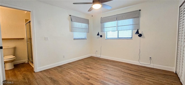 unfurnished bedroom with a ceiling fan, wood finished floors, and baseboards