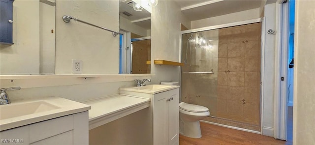 full bath featuring double vanity, a stall shower, wood finished floors, and a sink