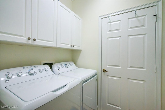 clothes washing area with cabinet space and independent washer and dryer