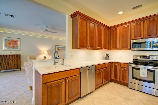 kitchen featuring visible vents, stainless steel appliances, a sink, and ornamental molding