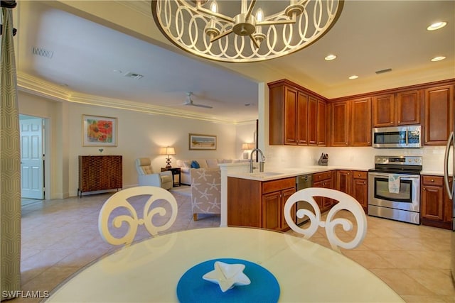 kitchen featuring appliances with stainless steel finishes, open floor plan, visible vents, and ornamental molding