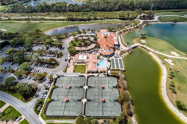 birds eye view of property with golf course view and a water view