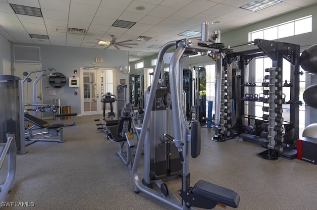 workout area featuring plenty of natural light, visible vents, ceiling fan, and a drop ceiling