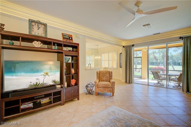 living area featuring light tile patterned floors, visible vents, ornamental molding, baseboards, and ceiling fan with notable chandelier