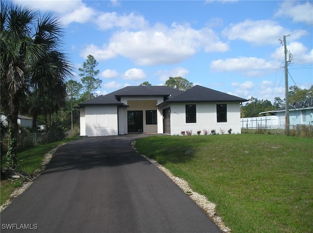 view of front facade featuring fence, a front lawn, aphalt driveway, and stucco siding