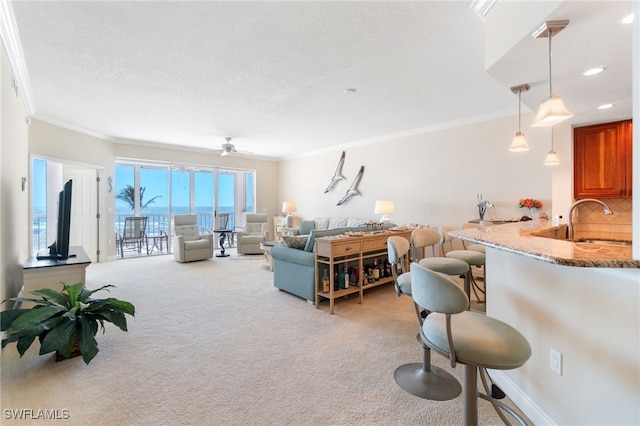 living area with crown molding, recessed lighting, light colored carpet, a ceiling fan, and a textured ceiling