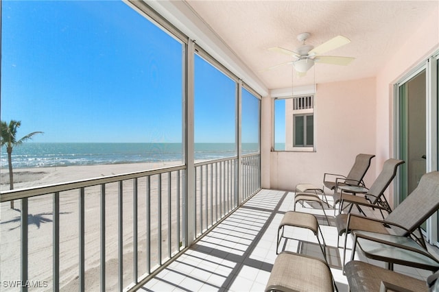 balcony featuring a water view, ceiling fan, and a view of the beach