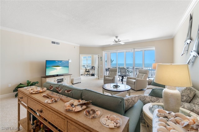 living area with carpet, visible vents, ornamental molding, a textured ceiling, and baseboards