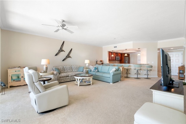 living area featuring crown molding, baseboards, a ceiling fan, and light colored carpet